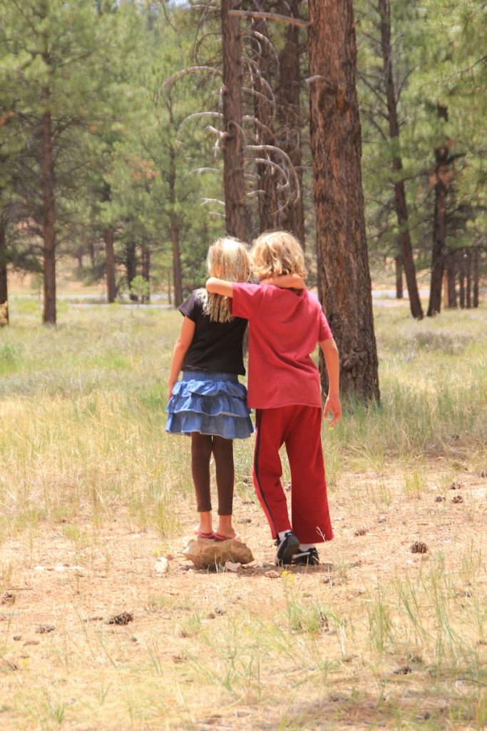 woman in red dress standing on brown grass field during daytime